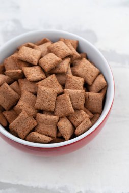 Seramik arka planda kırmızı kase çikolata yastıklar