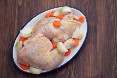 çanak havuç ve soğan ile çiğ tavuk bacaklar