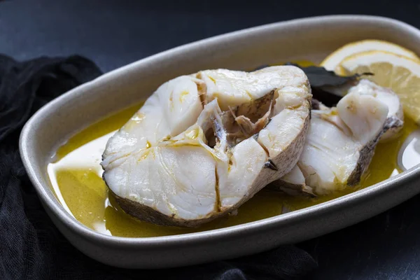 Pesce bollito con olio d'oliva in piatto su fondo ceramico — Foto Stock