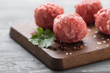 Ahşap tahta üzerinde biber ve tuz ile çiğ köfteler