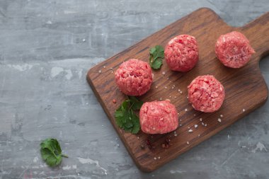 Ahşap tahta üzerinde biber ve tuz ile çiğ köfteler