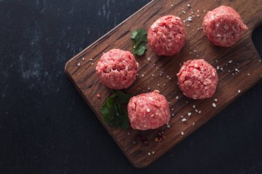 Ahşap tahta üzerinde biber ve tuz ile çiğ köfteler