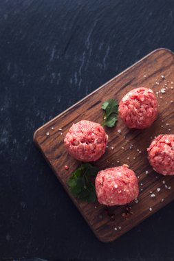 Ahşap tahta üzerinde biber ve tuz ile çiğ köfteler