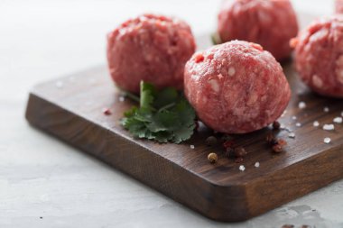 Ahşap tahta üzerinde biber ve tuz ile çiğ köfteler