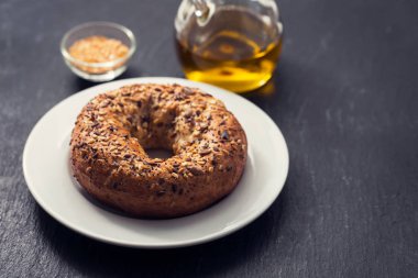 seramik arka plan üzerinde beyaz plaka üzerinde tohumlu taze simit