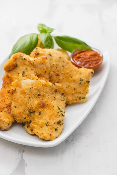 Gebratene Hühnerbrust mit Sauce auf weißem Teller auf keramischem Backblech — Stockfoto