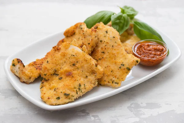 Gebratene Hühnerbrust mit Sauce auf weißem Teller auf keramischem Backblech — Stockfoto