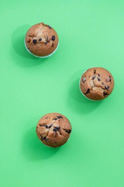 yeşil arka plan üzerinde beyaz çanak çikolata ile muffins