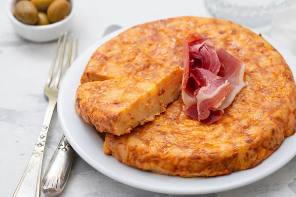 typical spanish food Tortilla with smoked meat and potato on whi