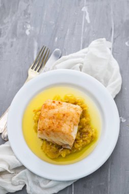 cod fish with mashed potato and olive oil on white dish clipart