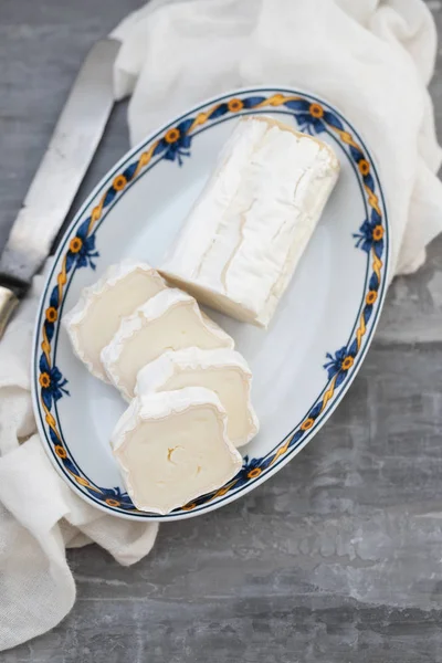 Ziegenkäse auf Teller auf keramischem Hintergrund — Stockfoto