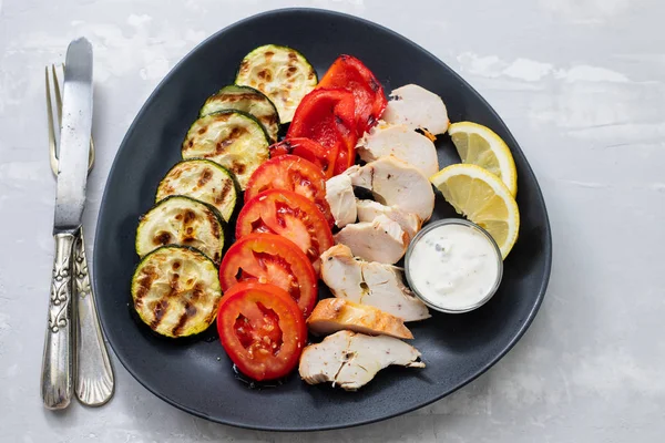 Grilled chicken with grilled vegetables with lemon and sauce on — Stock Photo, Image