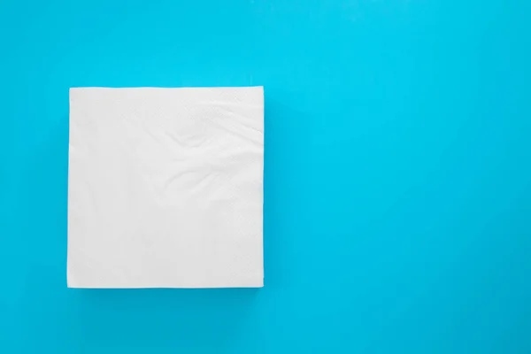 Mavi arkaplanda beyaz kağıt peçeteler — Stok fotoğraf