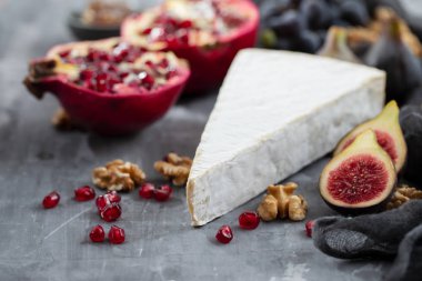 Peynirli incirler ve seramik zemin üzerinde nar.