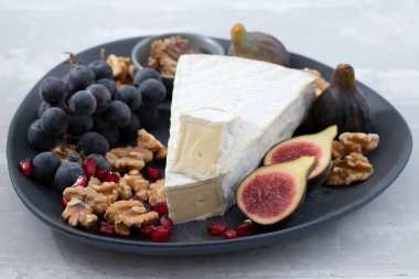 Peynirli incirler ve seramik zemin üzerinde nar.