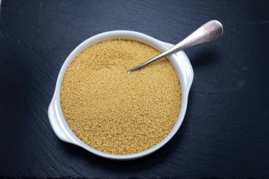 Siyah seramik arka planda beyaz kasede kuskus.