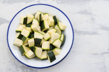Beyaz tabakta küp şeklinde taze kabak.
