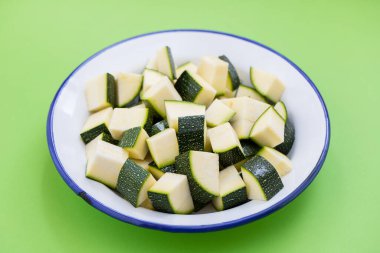 Beyaz tabakta küp şeklinde taze kabak.