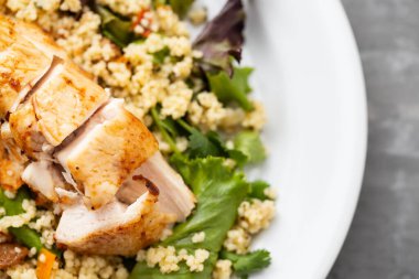 Sebzeli tavuk ve seramik arkaplanda kinoa.