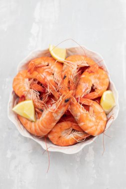 Beyaz kasede taze limonlu haşlanmış karides. 