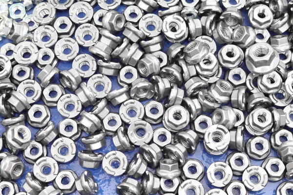 Small bolts and nuts by manufacturing process — Stock Photo, Image