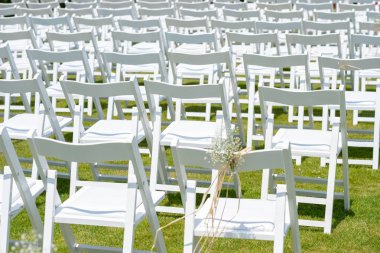 Beyaz çiçeklerle süslü sandalyeler, düğün töreni bölgesi olarak