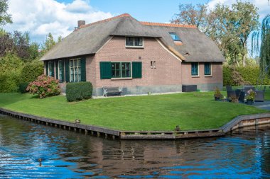 Kanallar ve rustik thatched çatı ile Giethoorn köy evleri 