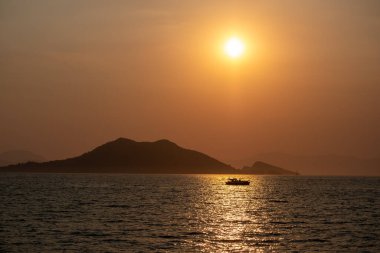 Güneş batarken denizde kayık