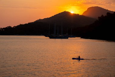 Güneş batarken denizdeki kano
