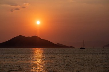 Güneş batarken denizde kayık