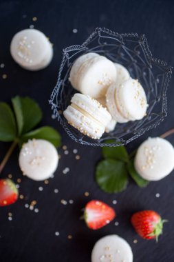 Prosecco macarons karanlık yüzey, seçici odak doldurma çilek ile