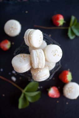 Prosecco macarons karanlık yüzey, seçici odak doldurma çilek ile