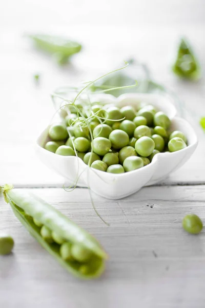 Guisantes Verdes Frescos Pelados Tazón Blanco Sobre Mesa Madera Blanca —  Fotos de Stock