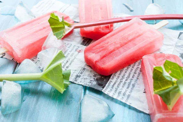 Refreshing Rhubarb Popsicles Blue Wooden Background Newspaper Article — Stock Photo, Image