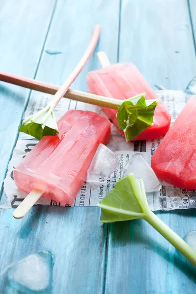 Refreshing Rhubarb Popsicles Blue Wooden Background Newspaper Article — Stock Photo, Image