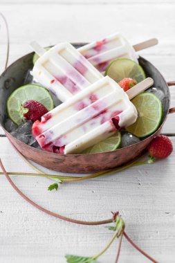 Çilek ve ahşap masa üzerinde bir kapta limon ile yapılan lezzetli popsicles