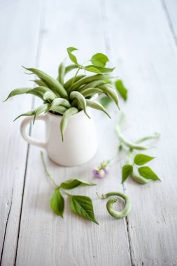 Ahşap masa üzerinde beyaz fincan yeşil fasulye gıda kompozisyonu