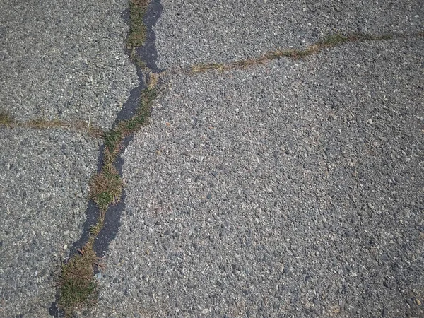 古いアスファルトの道路の質感 アスファルトはタールで満たされた亀裂で覆われており 草は亀裂で成長します — ストック写真