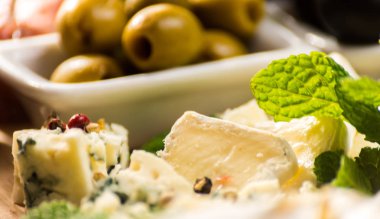 Tahtadaki farklı peynirler, peynir tahtası, lezzetli atıştırmalıklar, sağlıklı ve özel yemekler, peynir takımı.