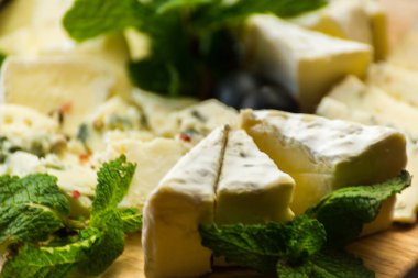 Tahtadaki farklı peynirler, peynir tahtası, lezzetli atıştırmalıklar, sağlıklı ve özel yemekler, peynir takımı.