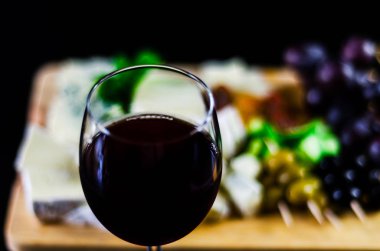 Kırmızı şarap ve bir tahta masa, lezzetli Aperatif, sağlıklı ve özel gıda üzerinde farklı peynir kümesi