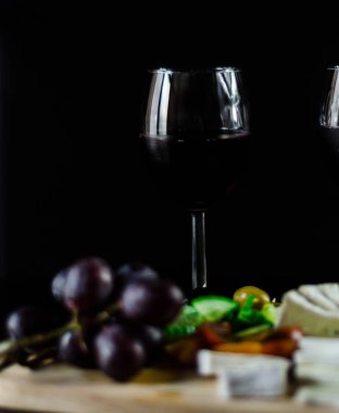 Kırmızı şarap ve bir tahta masa, lezzetli Aperatif, sağlıklı ve özel gıda üzerinde farklı peynir kümesi