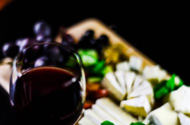 Kırmızı şarap ve bir tahta masa, lezzetli Aperatif, sağlıklı ve özel gıda üzerinde farklı peynir kümesi