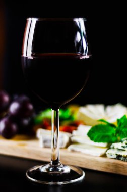 Kırmızı şarap ve bir tahta masa, lezzetli Aperatif, sağlıklı ve özel gıda üzerinde farklı peynir kümesi