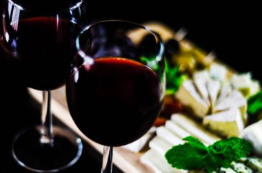 Kırmızı şarap ve bir tahta masa, lezzetli Aperatif, sağlıklı ve özel gıda üzerinde farklı peynir kümesi