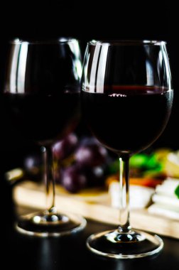 Kırmızı şarap ve bir tahta masa, lezzetli Aperatif, sağlıklı ve özel gıda üzerinde farklı peynir kümesi