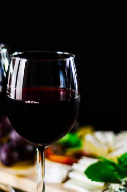 Kırmızı şarap ve bir tahta masa, lezzetli Aperatif, sağlıklı ve özel gıda üzerinde farklı peynir kümesi