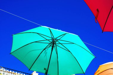Renkli şemsiyeler kentsel sokak dekorasyon. Mavi gökyüzü, turistik, güneşli gün asılı renkli şemsiyeler
