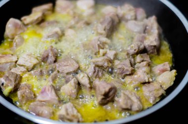 Tereyağı kızarmış parçalar halinde kesilmiş sulu domuz eti, kırmızı et bir tavada hazırlanan yemek