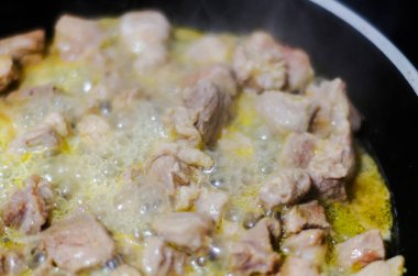 Tereyağı kızarmış parçalar halinde kesilmiş sulu domuz eti, kırmızı et bir tavada hazırlanan yemek